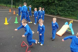 Primary 2 pupils enjoying a PE lesson (with help from the P7 pupils).